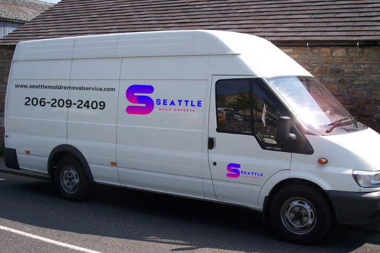 A white van is parked outside a building that houses a mold removal service in Seattle, WA.